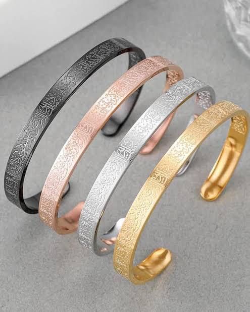 Set of four engraved Arabic calligraphy cuffs in black, rose gold, silver, and gold tones