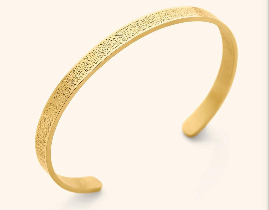 Gold open cuff bracelet featuring intricate Arabic calligraphy engraving