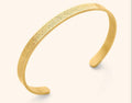 Gold open cuff bracelet featuring intricate Arabic calligraphy engraving