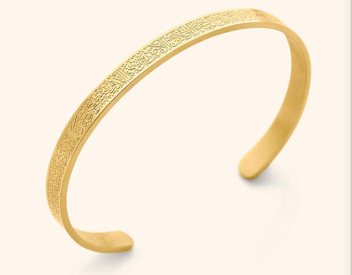 Gold open cuff bracelet featuring intricate Arabic calligraphy engraving